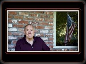 Author Ed Mitchell sitting on his porch