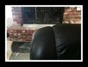 Lazyboy chair in foreground with fireplace in background