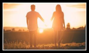 Couple holding hands watching the sunset.